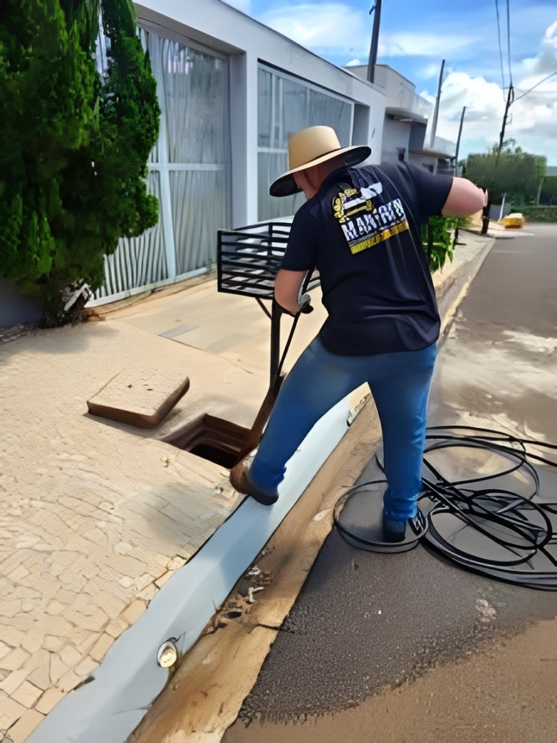 Técnico profissional da Manfrin Desentupidora em campo realizando o desentupimento com equipamentos reais